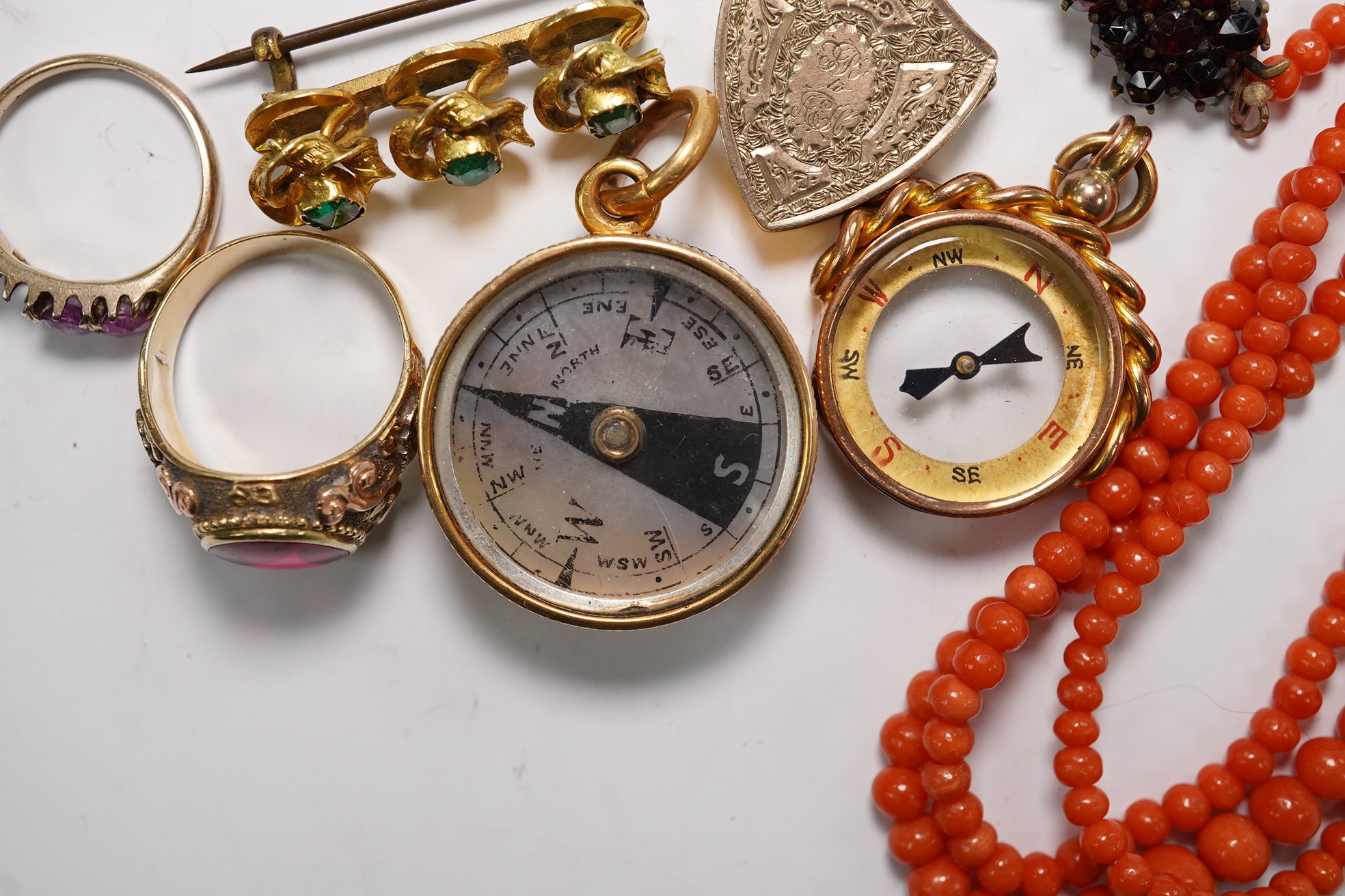 A small group of assorted jewellery including a coral necklace, 9c compass fob, five yellow metal items including a ring, locket and brooch and a stick pin. Condition - poor to fair